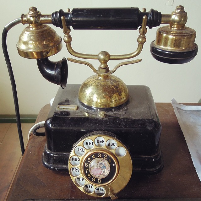 an old telephone sitting on top of a table