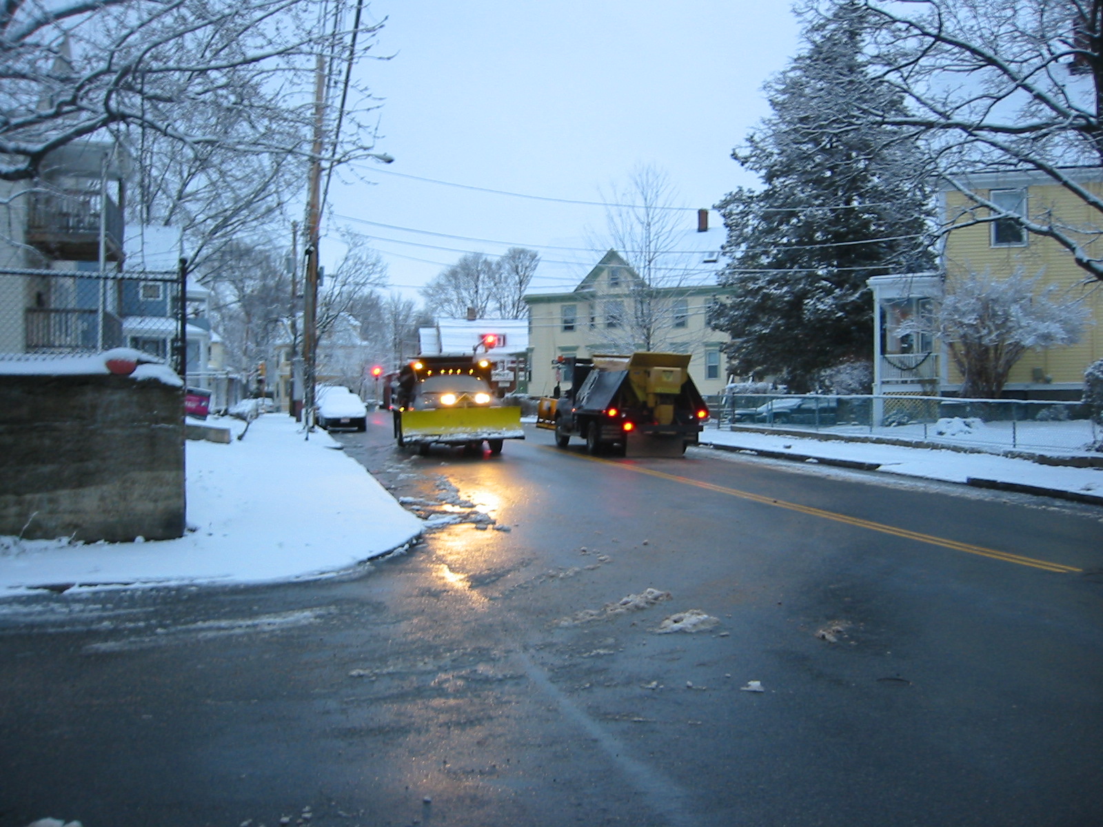 two yellow snowplows are on the road in the winter