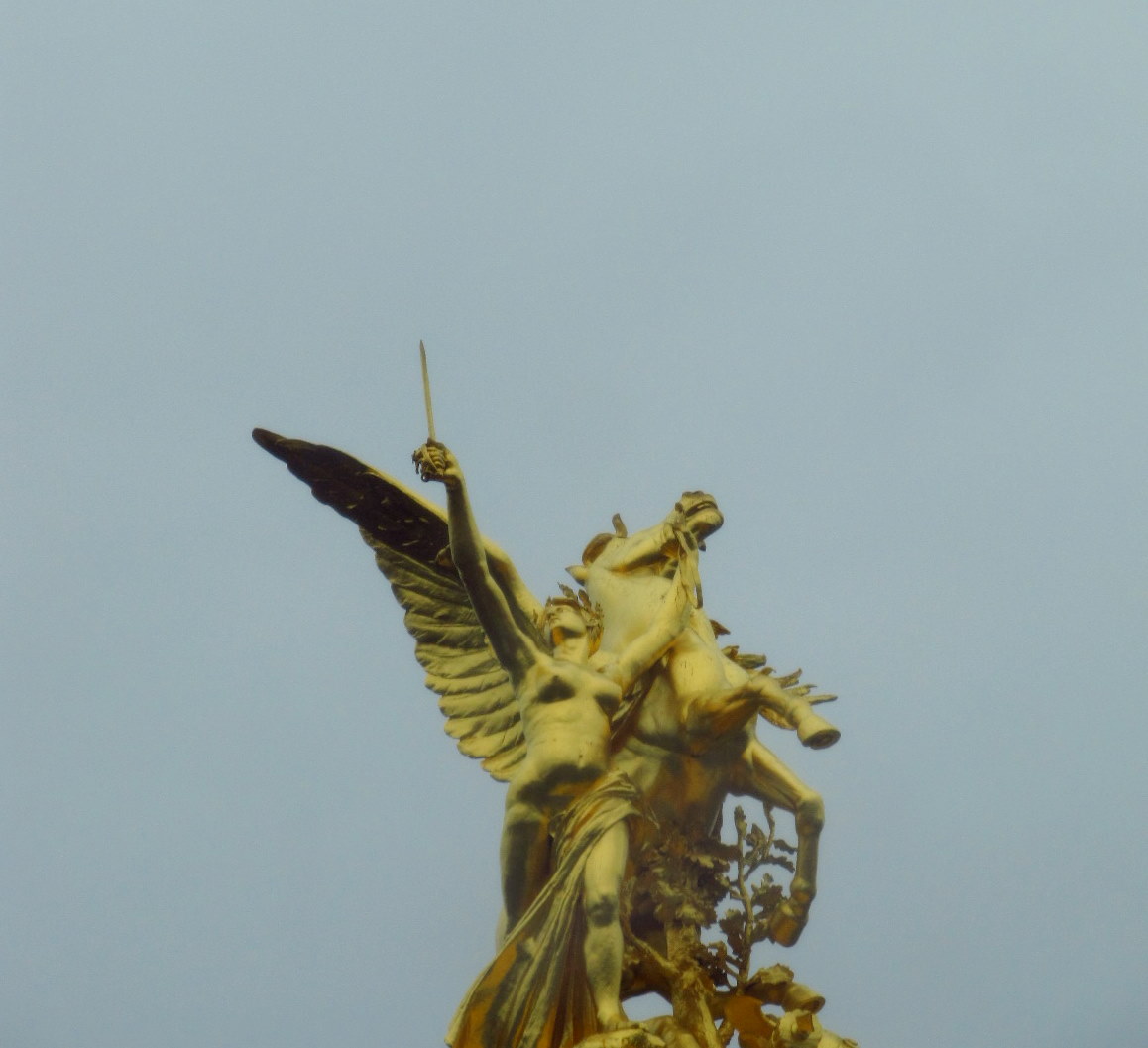 a large statue with a very tall winged figure