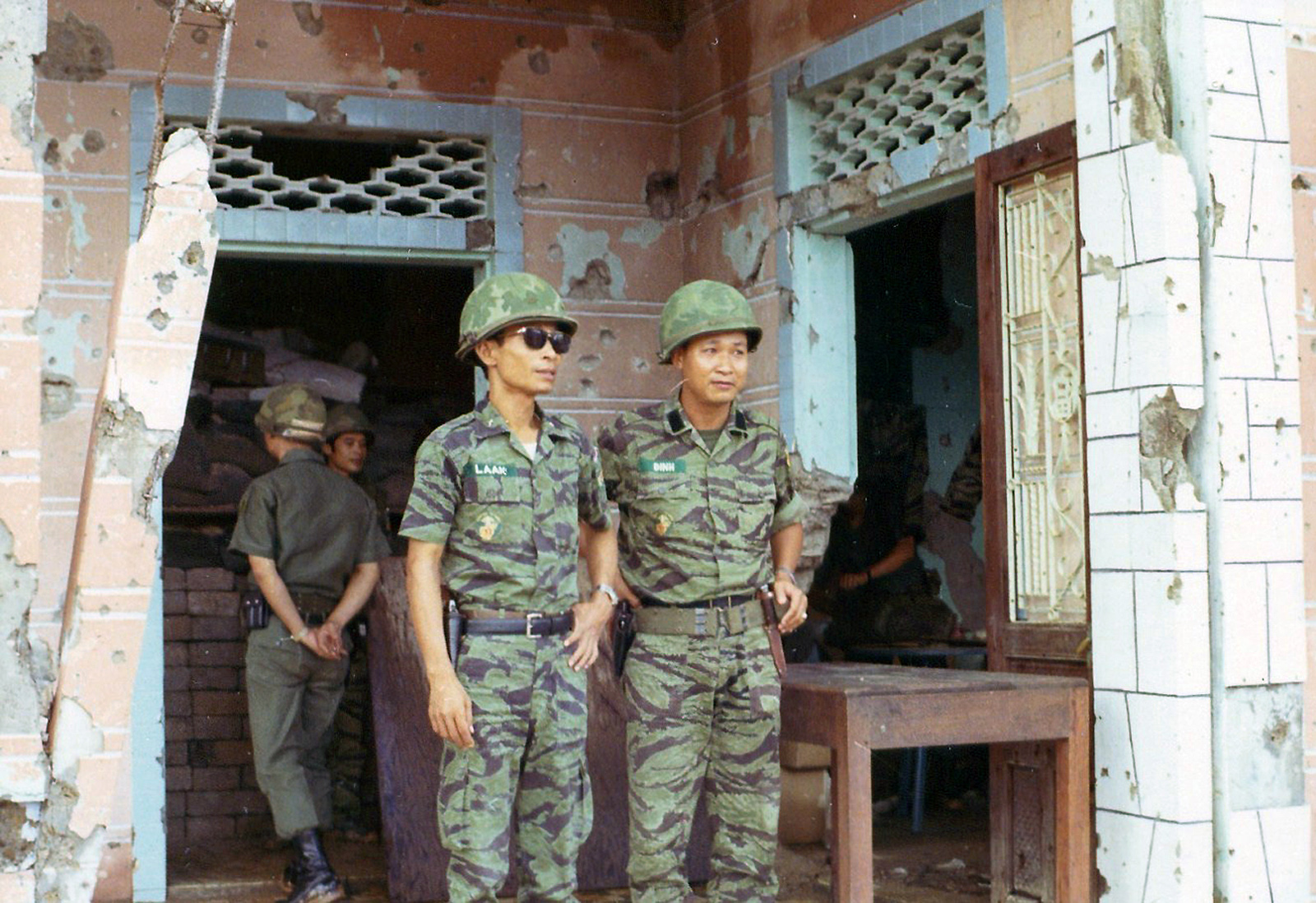 two soldiers standing next to each other outside of a building