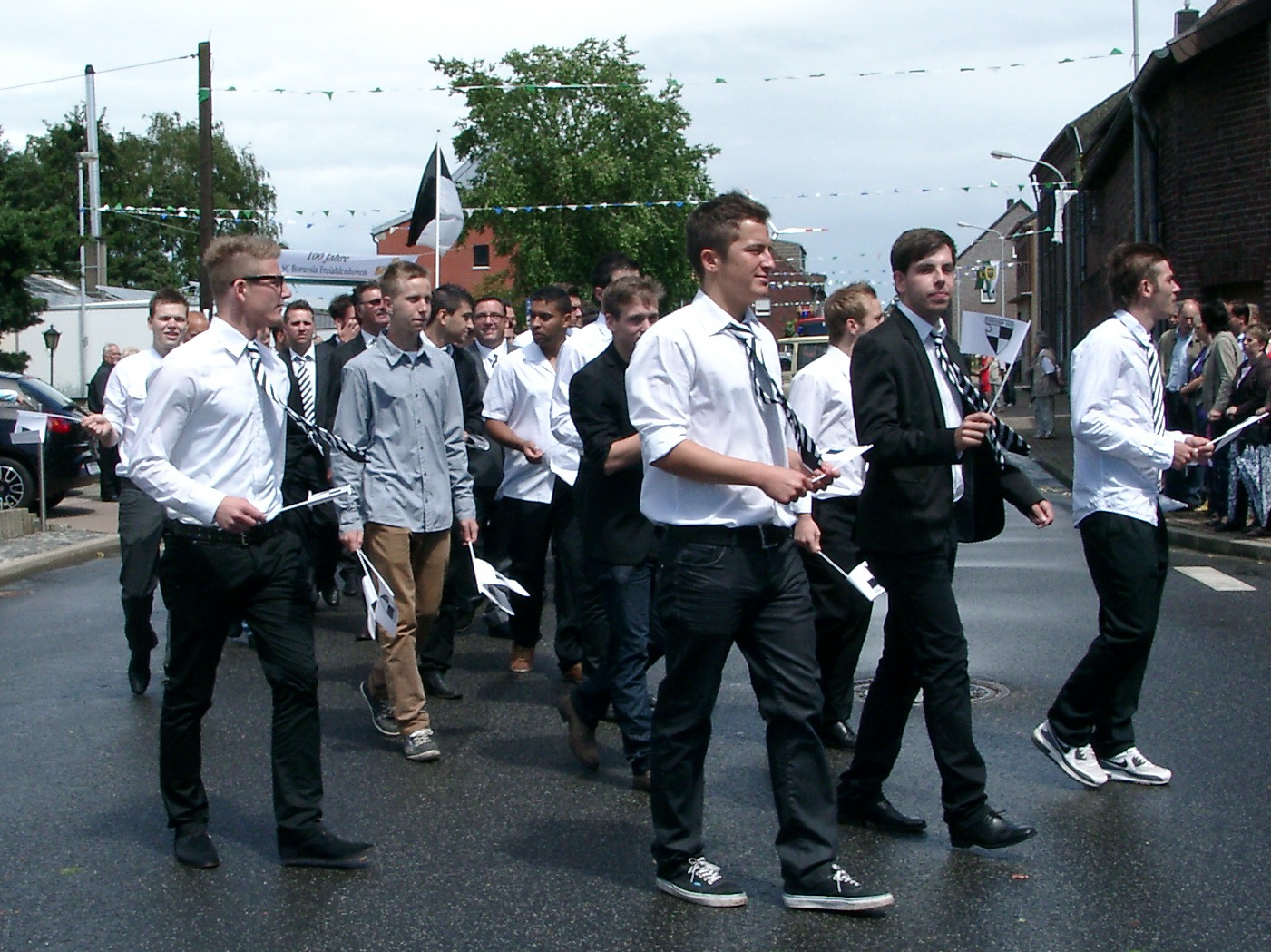the men are walking in the street with their ties on