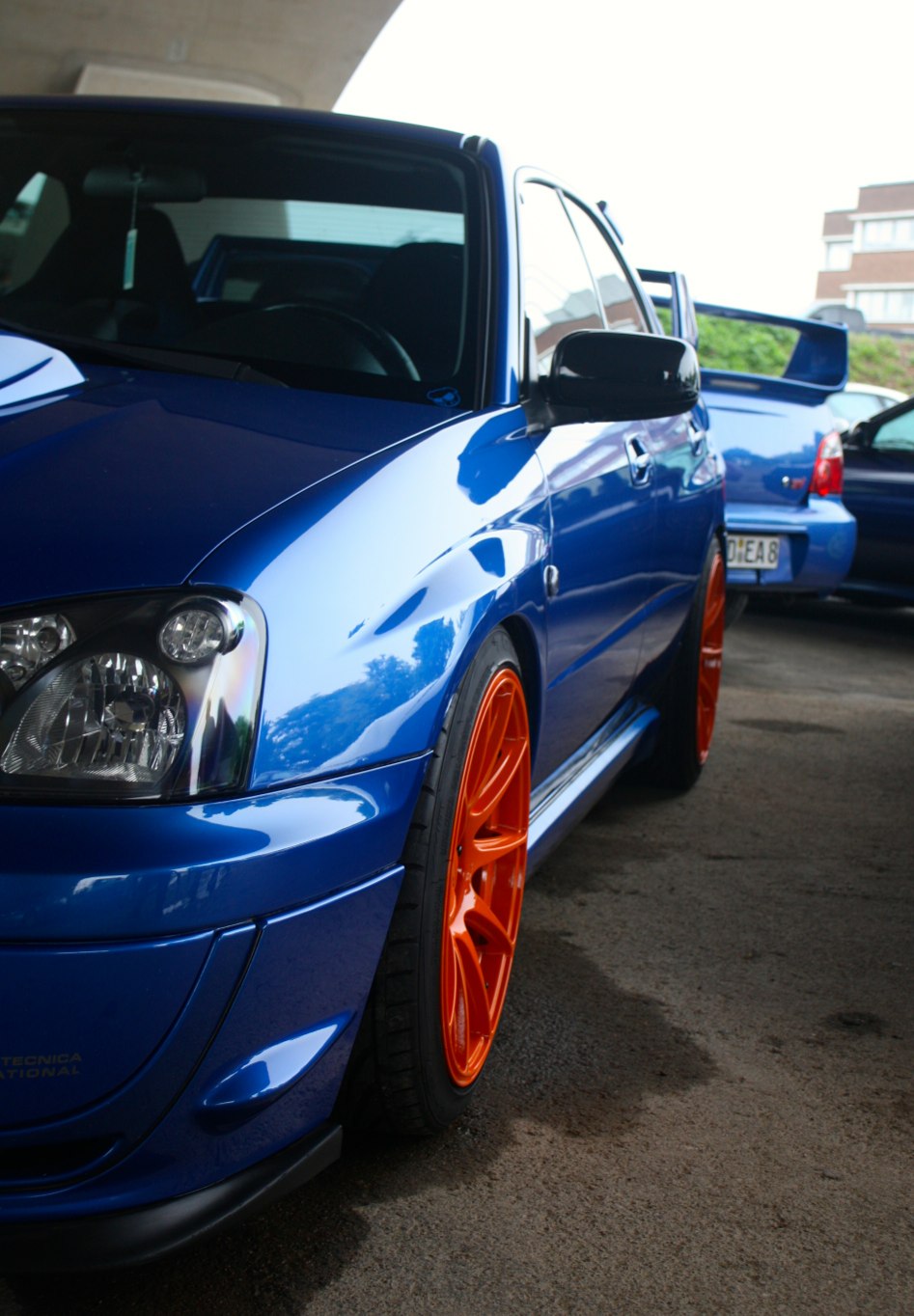 the front view of a blue car parked near other cars