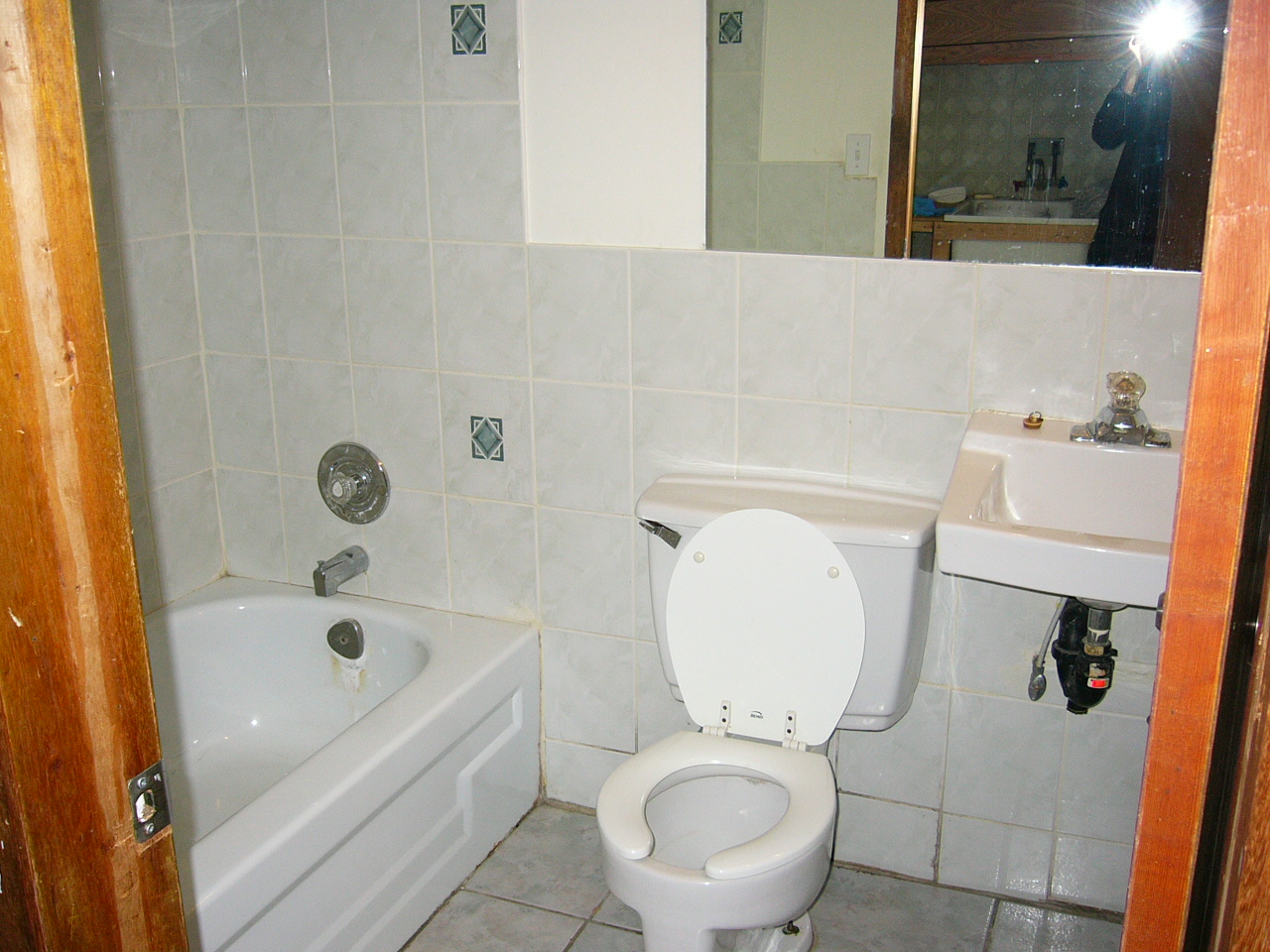 a bathroom with white tiled walls and floors
