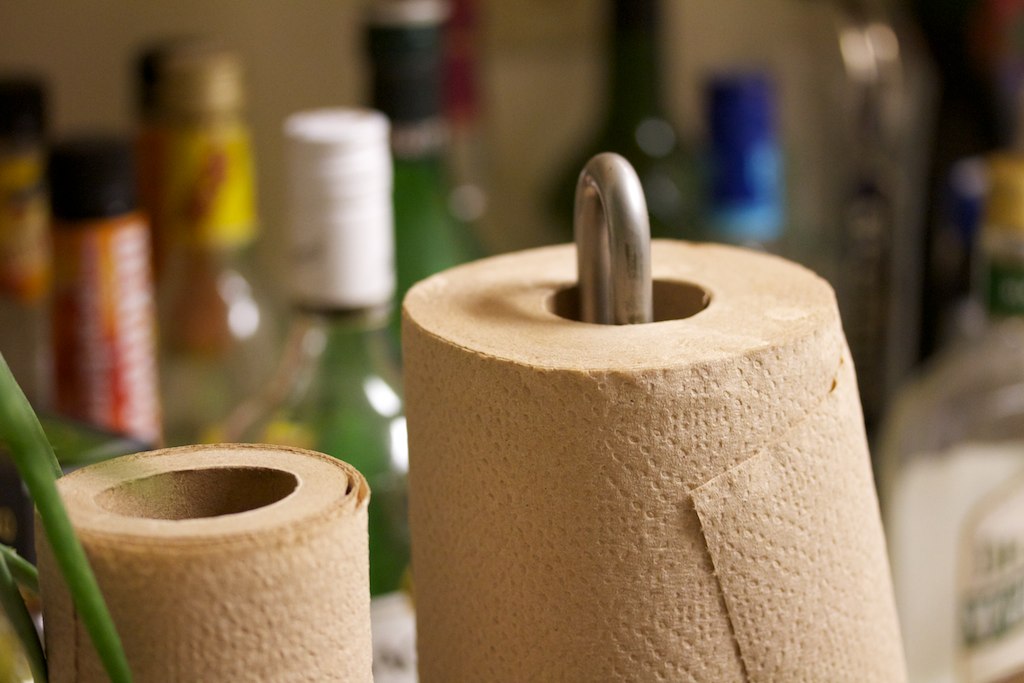 two toilet paper holders one is shaped like a banana and the other is made out of bamboo