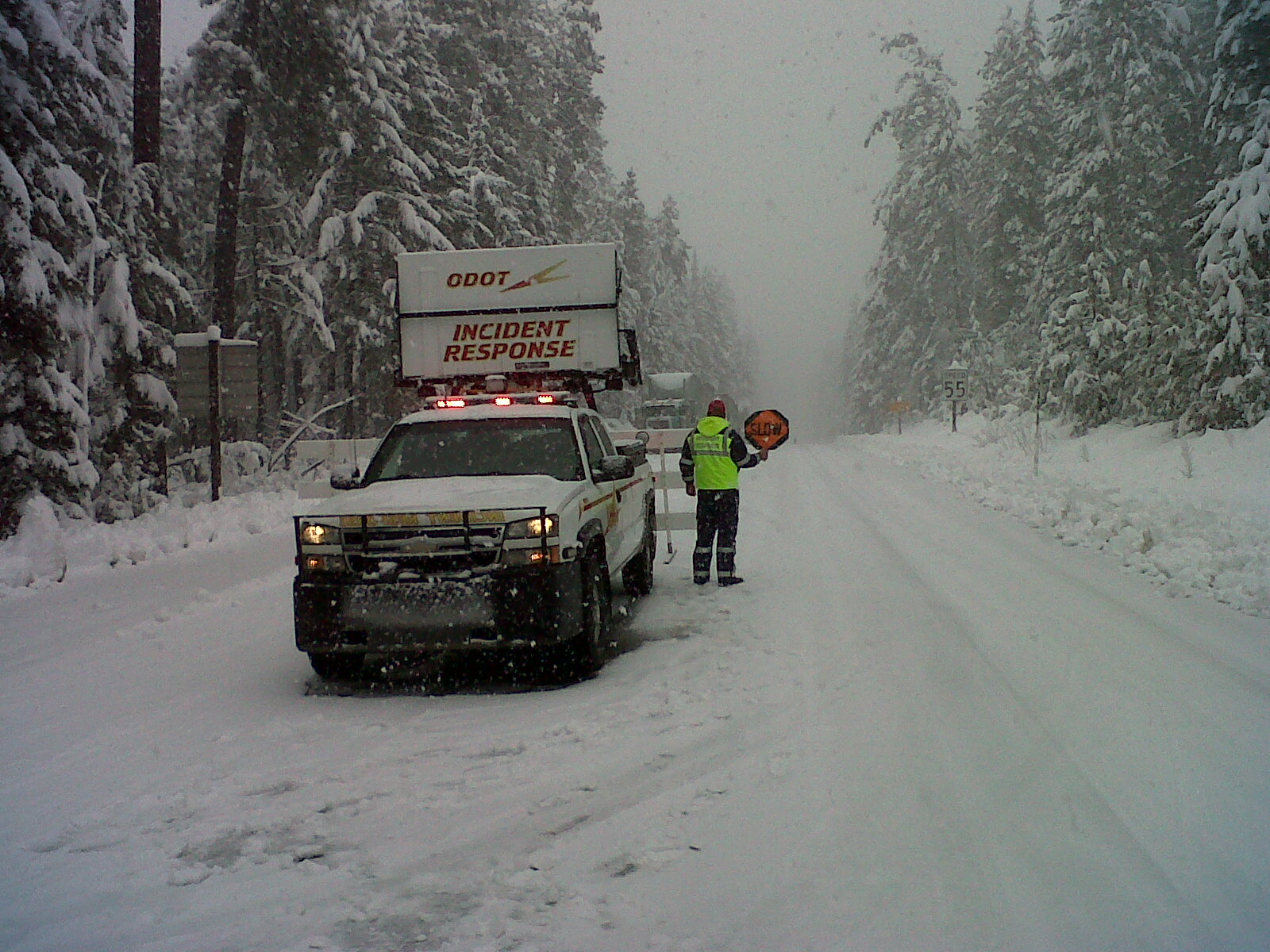 an emergency vehicle parked on the side of a snowy road