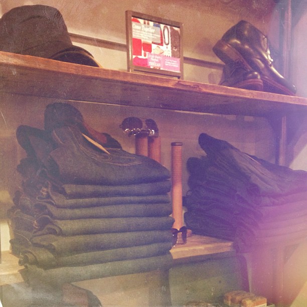 hats and footwear displayed on wooden shelf in shop