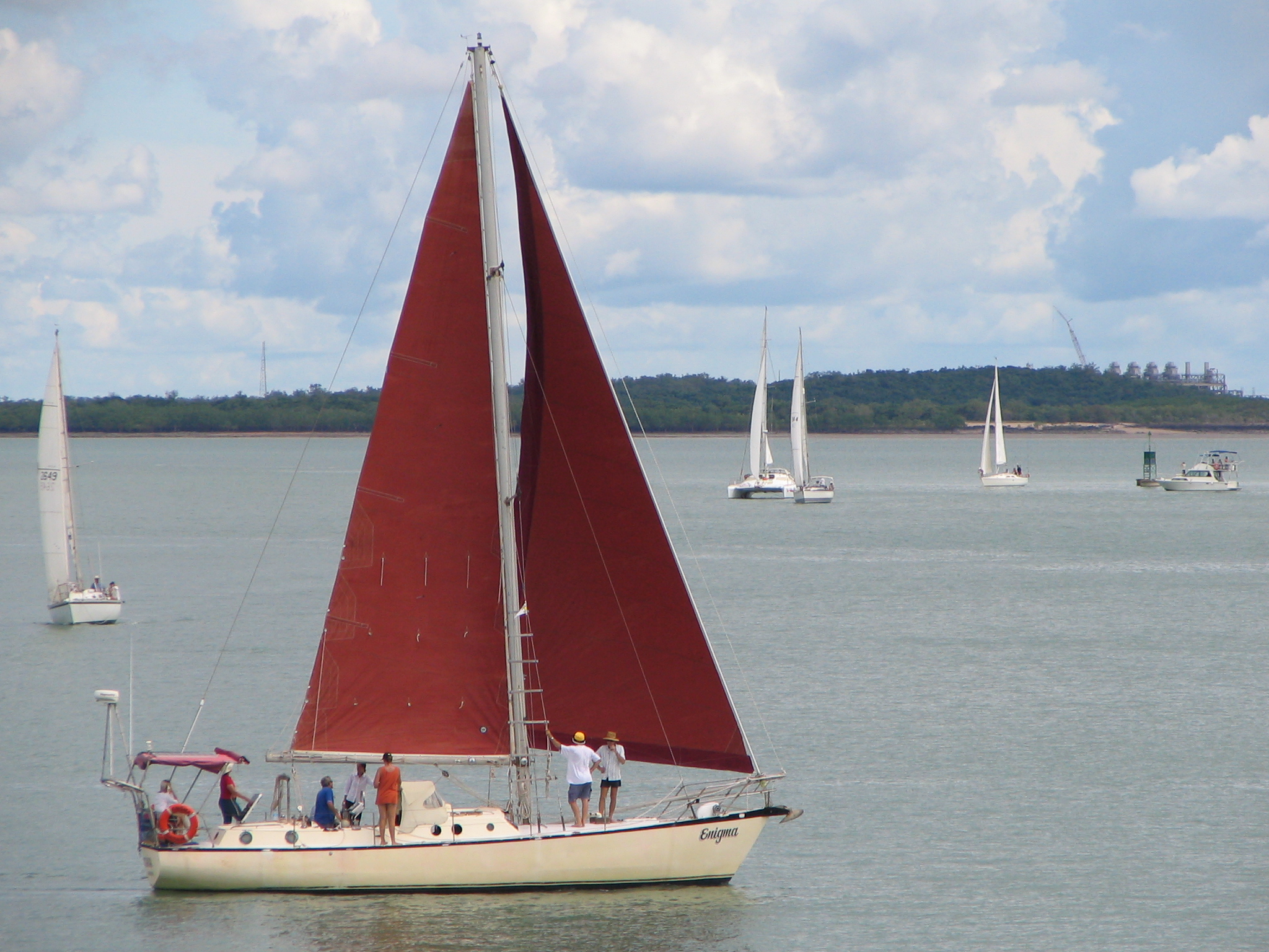 a large red sail boat is sailing in the ocean