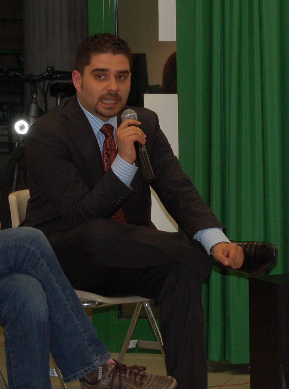 a man in a suit sits down with a microphone