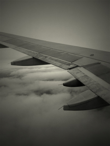 a view of the wing and clouds from an airplane window