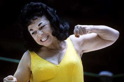 a woman smiling and stretching her arms to show muscles