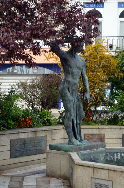 a sculpture of a man holding a tree in his hands