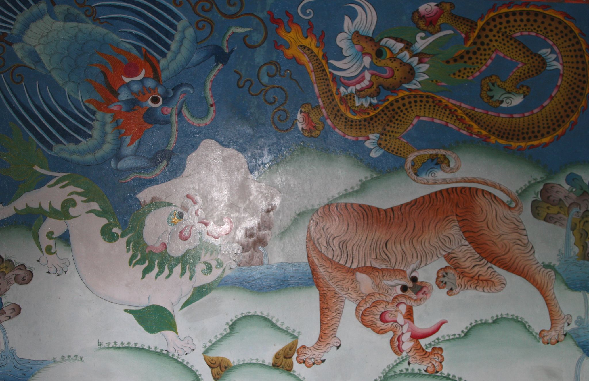a colorful painted wall with dragon, lion and fish in the middle