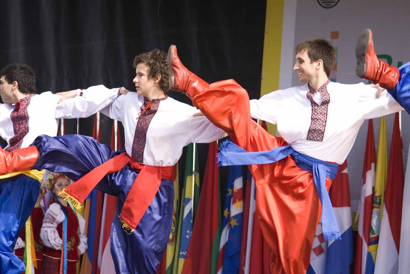 three men in costumes are practicing in front of a bunch of flags