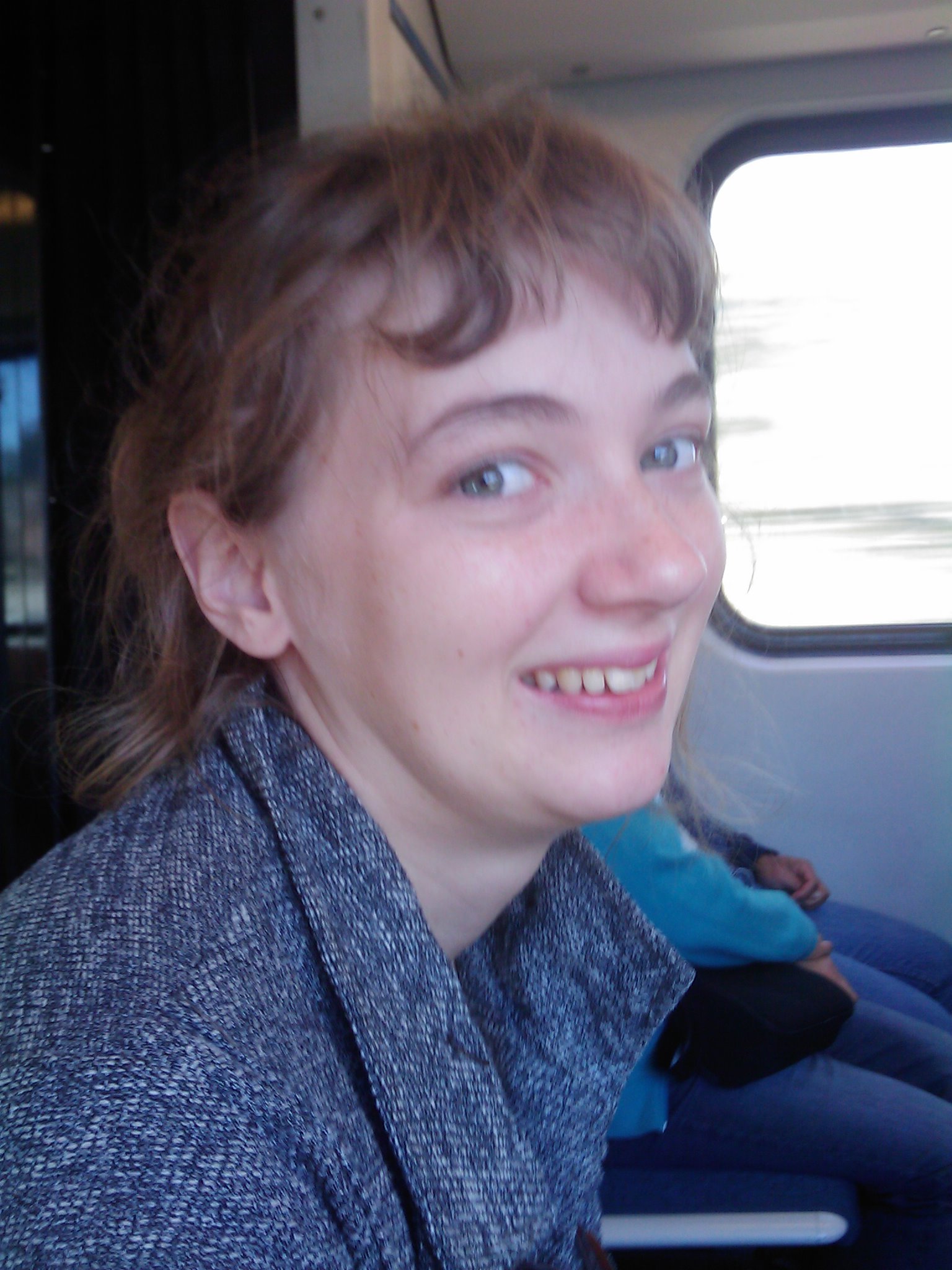 the woman is sitting on a bus while smiling