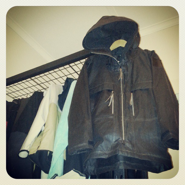 an old jacket is hanging up next to the coat rack