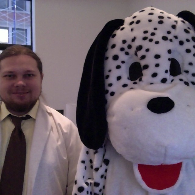 man standing next to a large stuffed dog