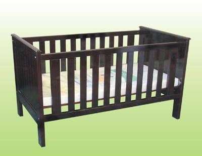 a brown baby crib that has a pillow on it