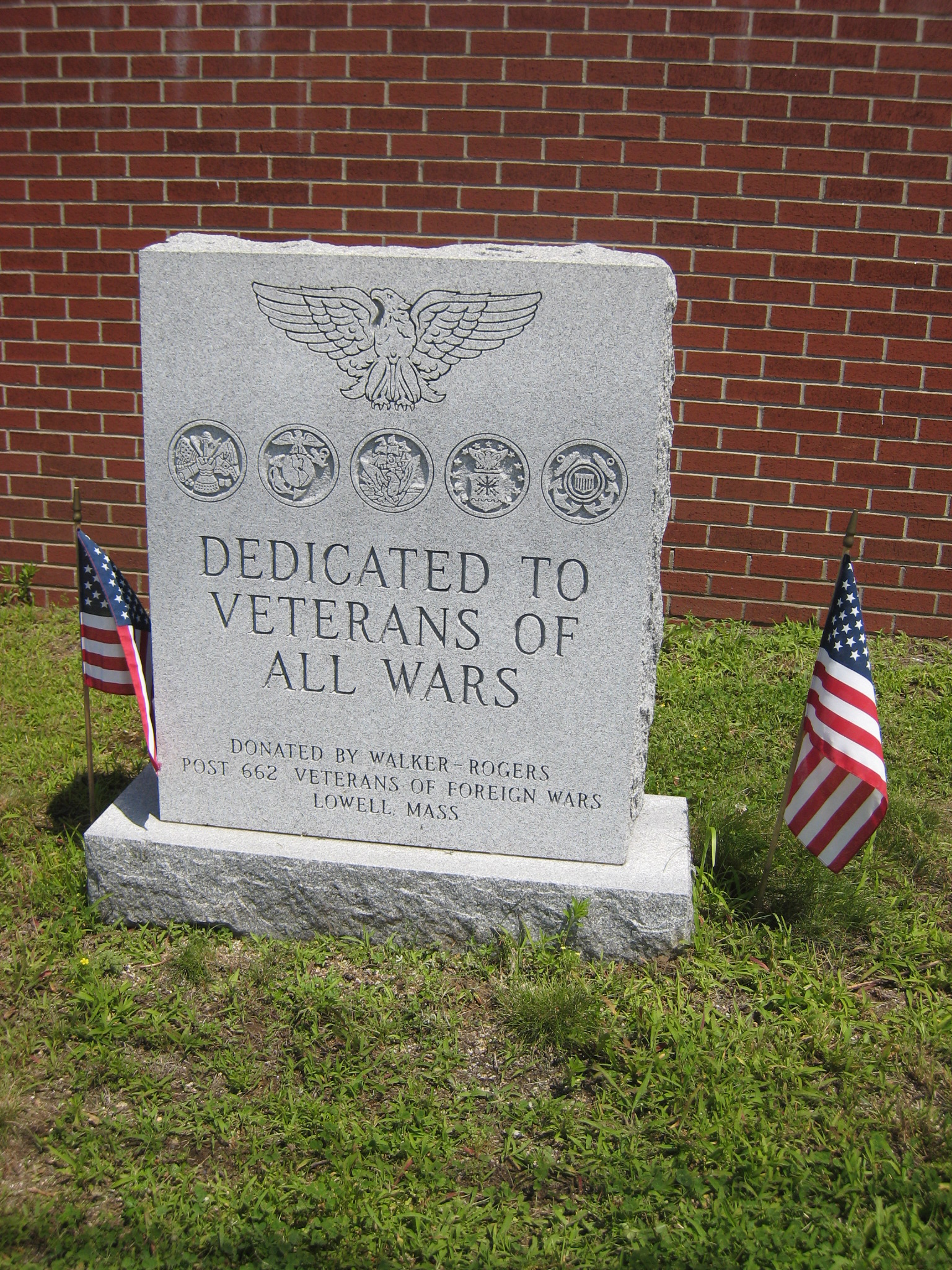 flags and a granite sign on the grass