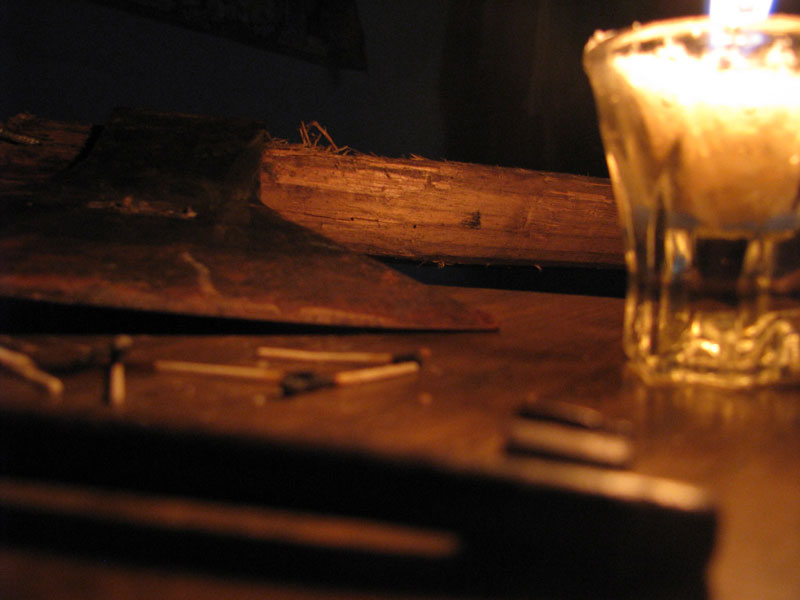 a candle is lit near some nails on a table