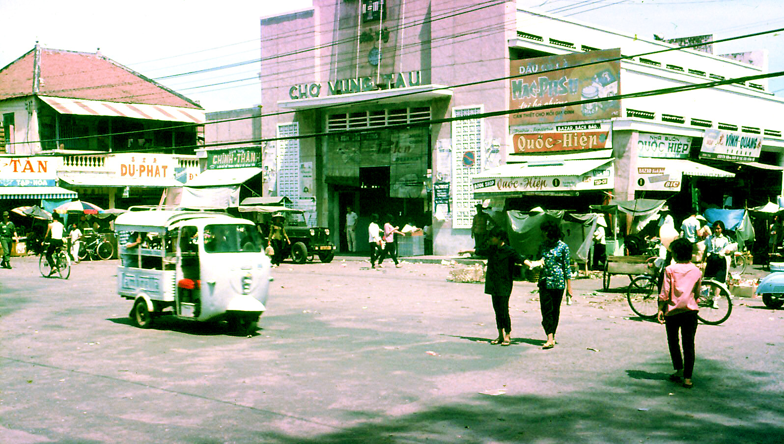 a street scene with an old bus and people
