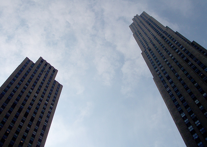 the towers are very tall and have a cloudy sky