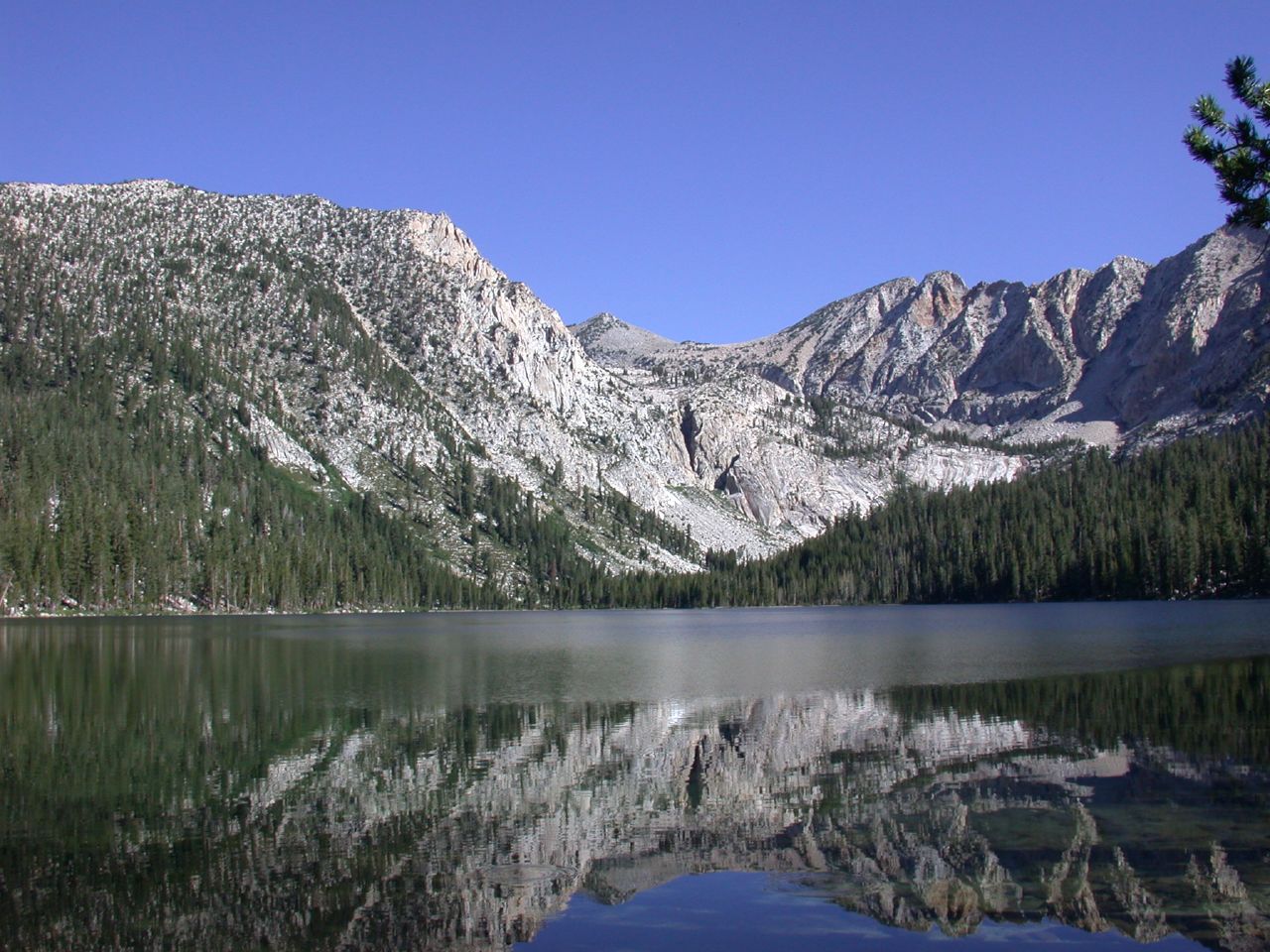 a mountain is behind a lake with mountains in the background