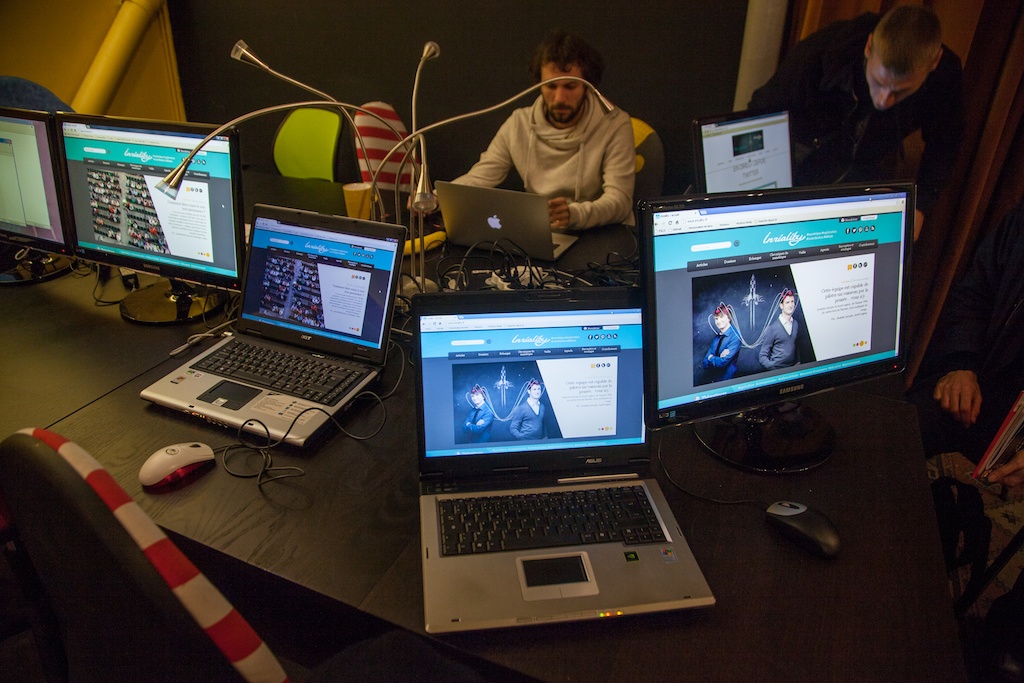 a man sitting at a table with many laptops