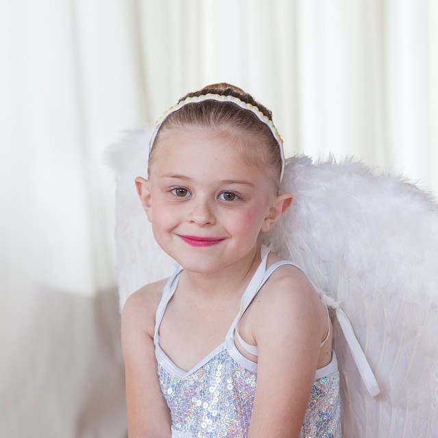 a little girl wearing an angel costume posing for a po