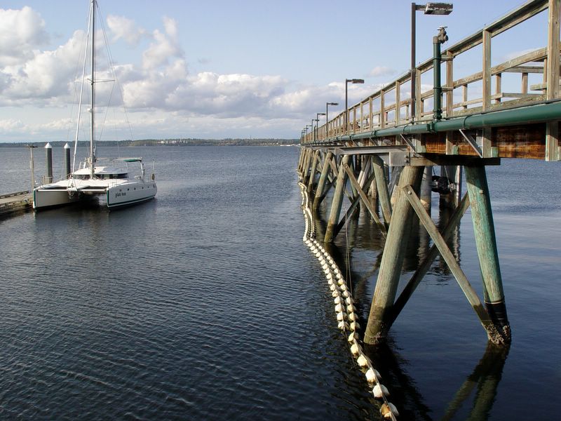 a sailboat is moored near a dock on a cloudy day