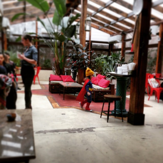 people in a greenhouse with many tables and sofas