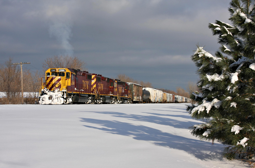 a train engine and cars riding along a snowy track