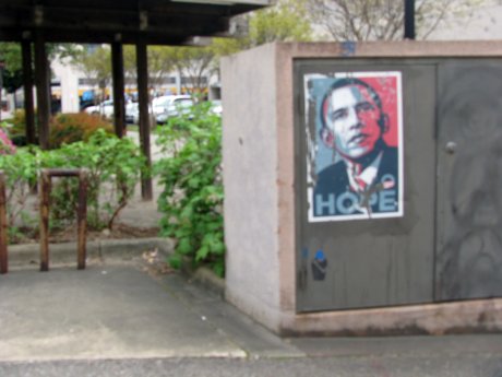 a street sign and a post with the image of president obama