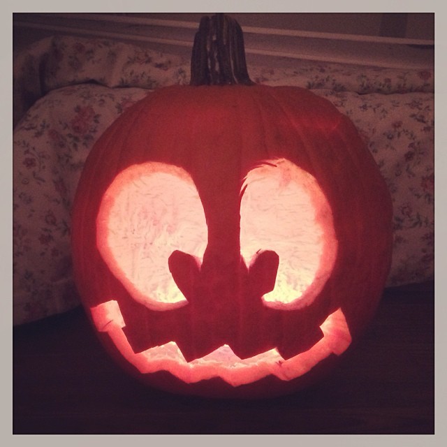 a lit up pumpkin with a face carved into it