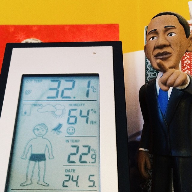 a clock has thermometer beside a toy man
