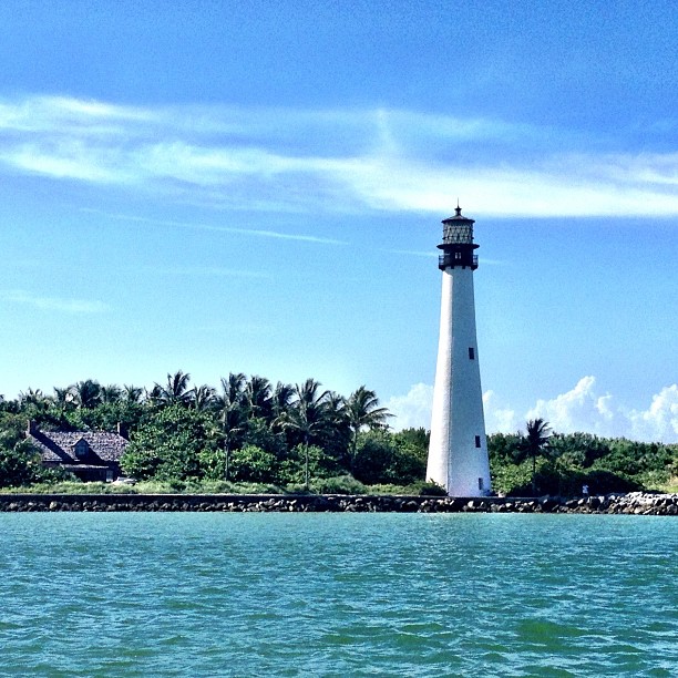 a white lighthouse sitting above the ocean