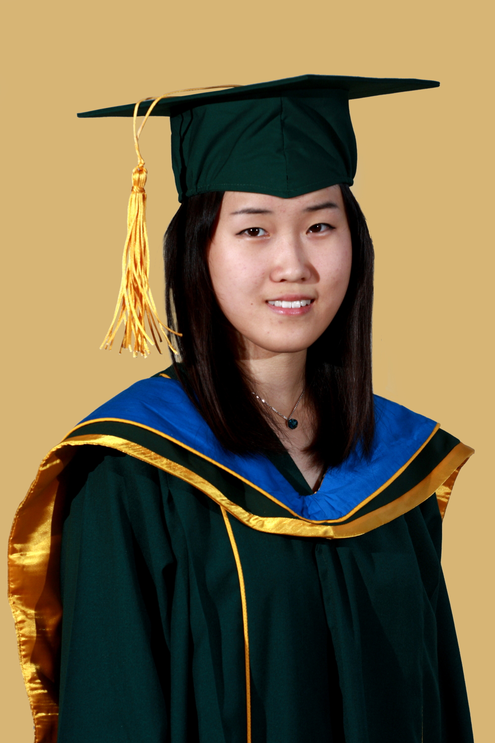 an asian student poses for the camera in her graduation gown