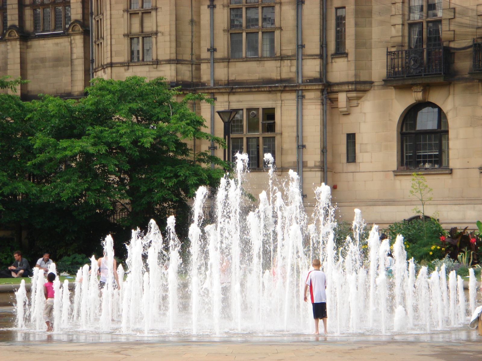 s play in a fountain outside of an old building