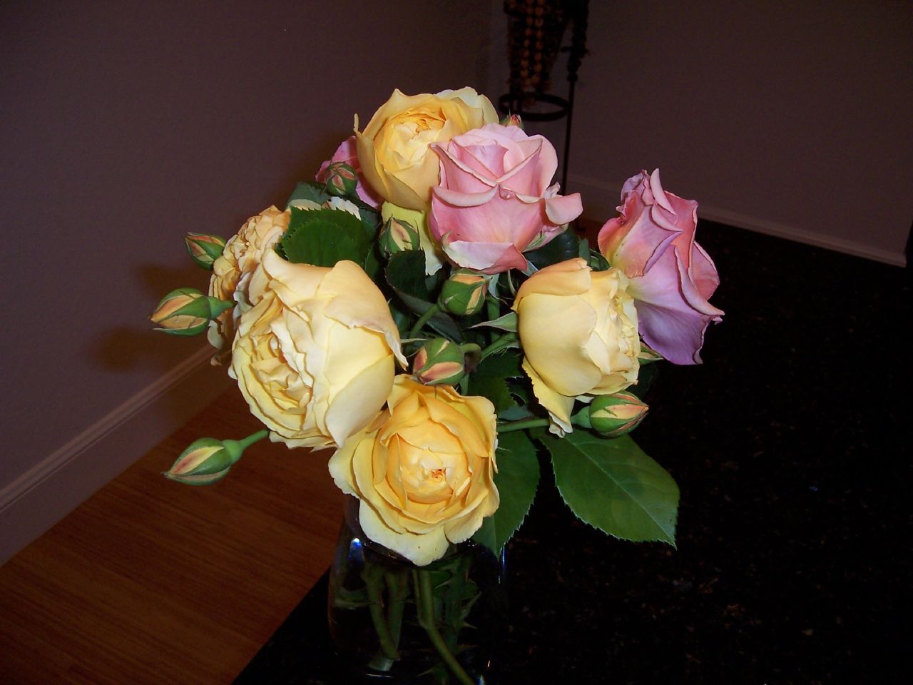 a vase filled with yellow and pink flowers on top of a table