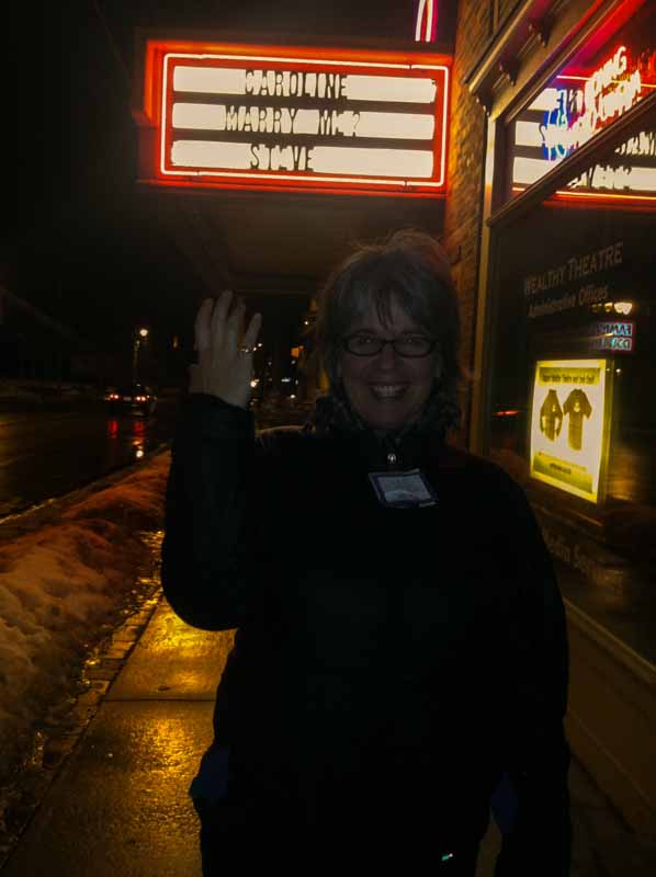 woman at night, holding her arms up in the air