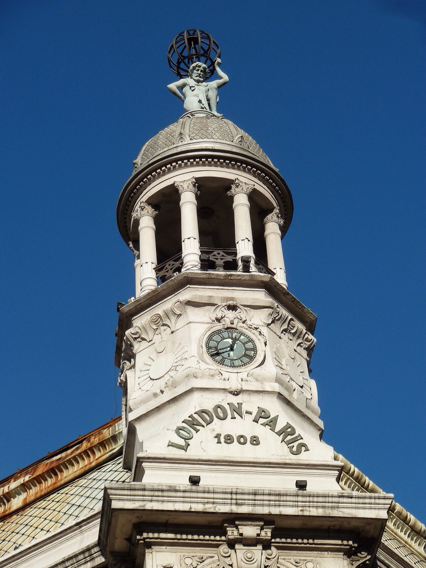 a clock tower with an angels head on top