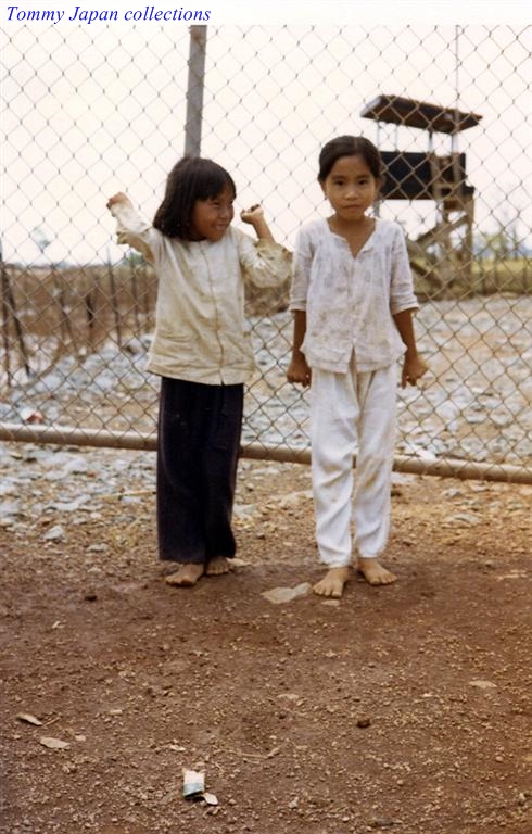 two little children in pajamas and a fence behind them