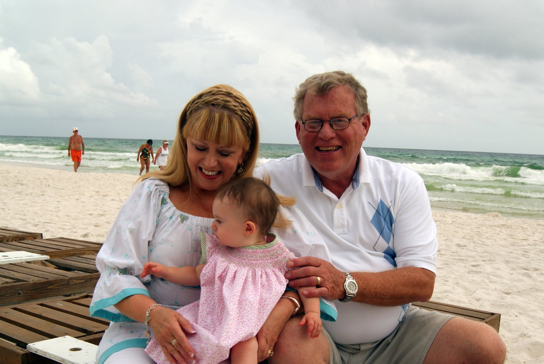 an old man is sitting on the beach with his wife