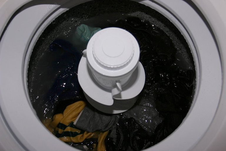 a machine filled with clothing and a bottle of water