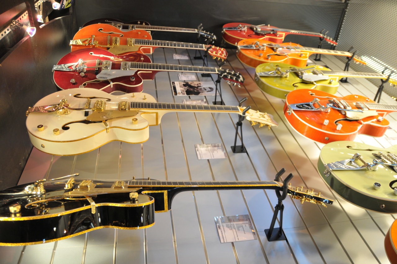 guitars hang on the wall in a store
