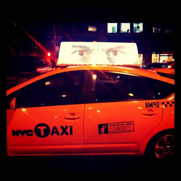 a taxi with a lot of eyes painted on the windshield
