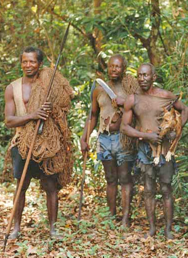 three men standing in the forest with spear, arrow and a dog