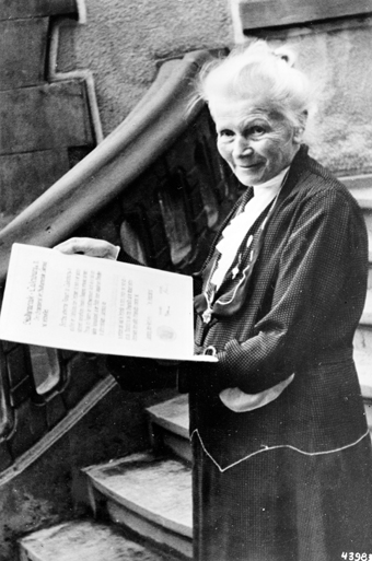 old woman on stairs with book in hand