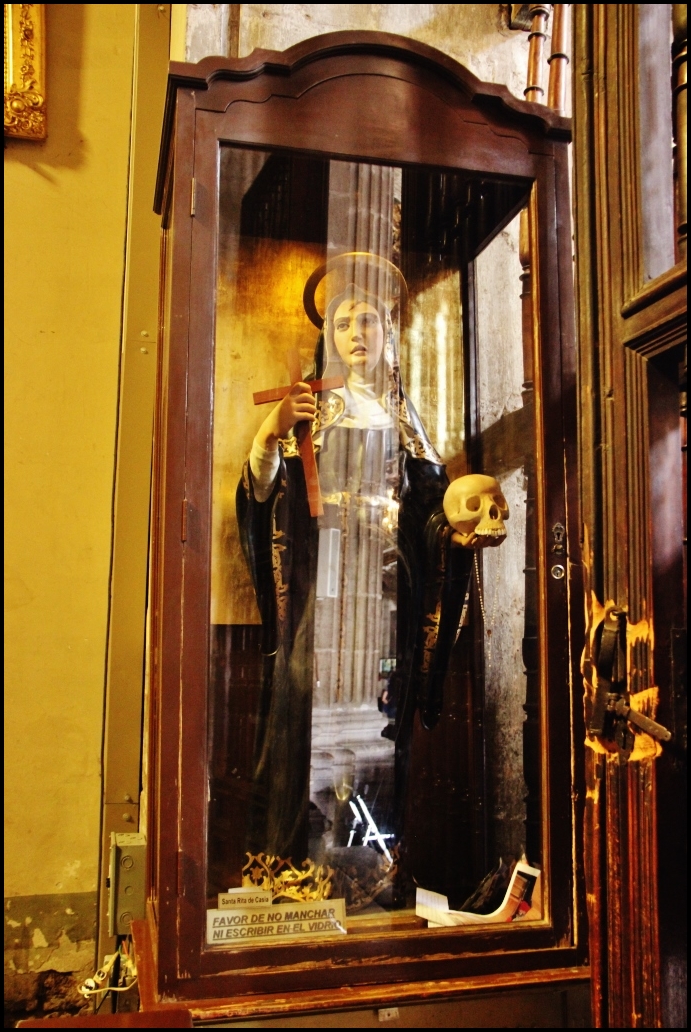 an antique mannequin in a window with skeleton heads