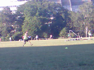 an outdoor field with people playing soccer and playing soccer