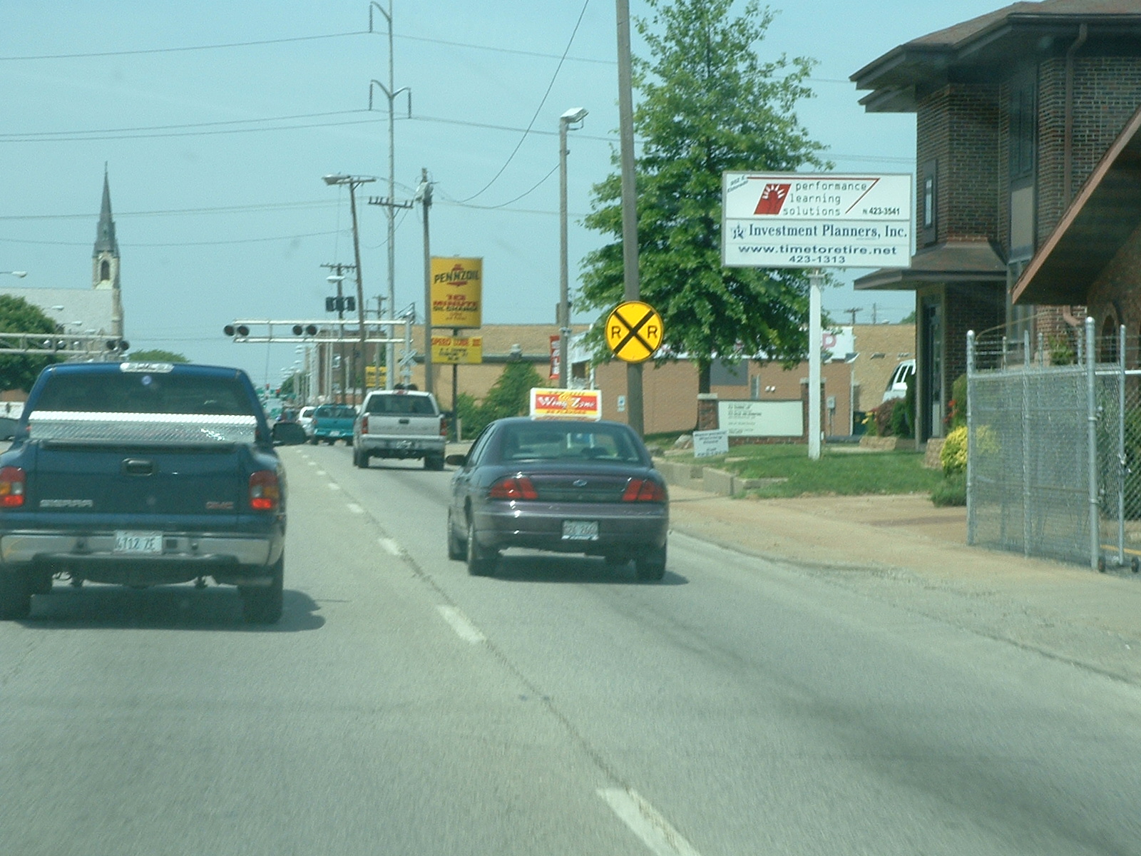 two cars driving on a road in front of an information center